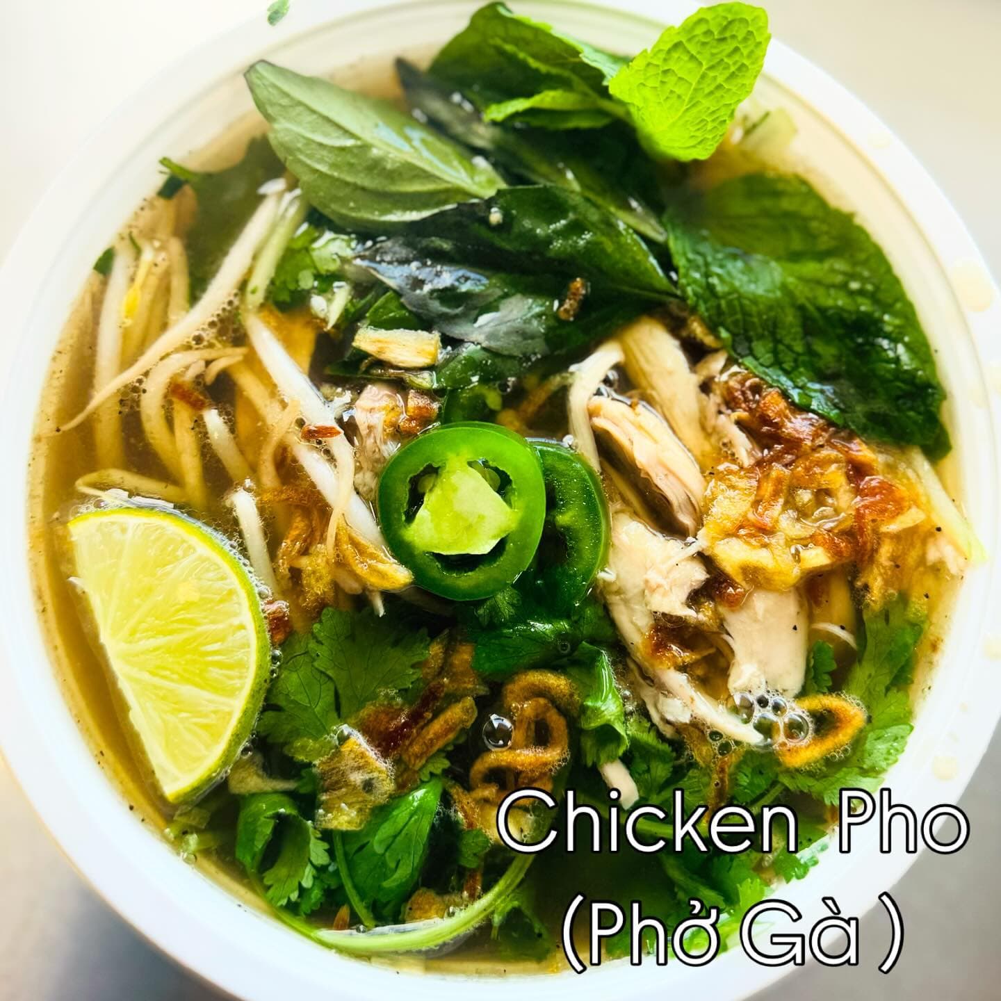 Chicken pho (phở gà) with fresh herbs, lime, and jalapeño